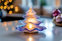Glowing glass Christmas tree decoration with warm LED light creating magical holiday ambiance on table with bokeh lights background for festive decor.