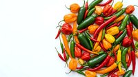 Colorful hot chili peppers mix on white background. Fresh spicy vegetables collection for cooking, seasoning and culinary projects isolated.