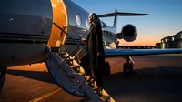 Woman in business attire boarding private jet at sunset, luxury travel and executive lifestyle concept for corporate transportation and premium aviation services.
