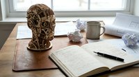 Wooden brain sculpture with intricate gears and mechanical details on desk with open notebook, pen and coffee mug representing creative thinking and innovation.