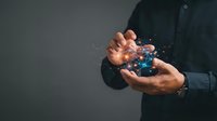 Close-up of male hands holding glowing digital globe with light particles and data streams, representing global connectivity, technology innovation, and worldwide business networks.