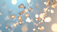 Delicate copper wire fairy lights with warm glowing bulbs creating magical bokeh effect against soft blue background for festive decoration and ambiance.