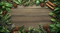 Fresh aromatic herbs and spices frame with basil, rosemary, star anise and cinnamon sticks on rustic wooden background, copy space in center for food styling.