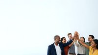Diverse group of professionals celebrating success with high five gesture, showing teamwork and unity in corporate environment.