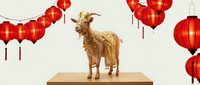 Golden goat figurine on wooden platform surrounded by red Chinese lanterns for Lunar New Year celebration and festive holiday decoration.