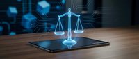 Digital justice scales hologram emerging from tablet on wooden desk with futuristic blue technology interface background for legal tech applications.