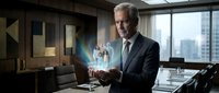 Senior Caucasian businessman in suit using holographic technology display in modern office boardroom with city skyline view for corporate presentations.
