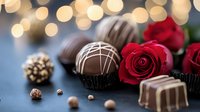 Luxury chocolate truffles and pralines with fresh red roses against blurred golden bokeh lights on dark background, romantic dessert setting.