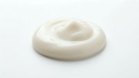 Creamy white cosmetic lotion swirl isolated on white background, ready for skincare product packaging, beauty advertising, and cosmetic design applications.