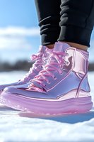Metallic pink platform boots with chunky sole and laces against snowy background, paired with black leggings, showcasing modern winter fashion and trendy footwear style.