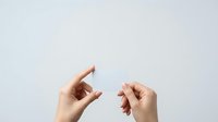 Two hands gesture small size measurement against neutral background, representing tiny amount, minimal quantity, or little space for design and advertising.