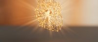 Modern geometric pendant light fixture with warm LED bulbs creating ambient lighting and shadow patterns on wall for contemporary interior design.