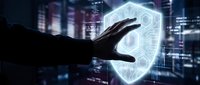 Hand touching glowing digital shield icon representing cybersecurity protection and data safety in futuristic cityscape background for business technology.