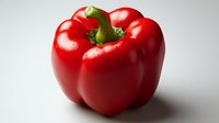 Fresh red bell pepper with green stem on white background, dramatic side lighting creates depth and texture for food photography and culinary designs.