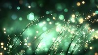 Magical emerald green bokeh background with glowing golden particles and curved light trails creating dreamy atmospheric effect for festive designs.