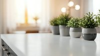 Modern kitchen counter with fresh herbs in ceramic pots creating clean minimalist cooking space for healthy lifestyle and home design concepts.