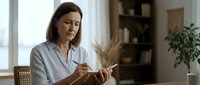 Middle-aged woman with brown hair and fair complexion reading a book indoors. Professional, educational, and lifestyle use for publishing and learning content.