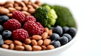 Fresh organic berries, almonds, and broccoli in white ceramic bowl. Healthy superfood mix of antioxidant rich fruits and nuts for nutritious eating and diet.