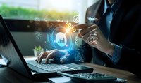 Business professional analyzing financial data with digital technology interface displaying charts and analytics icons on laptop screen.