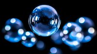 Transparent soap bubble floating in dark space with blue bokeh lights, creating magical atmosphere for fantasy or science concepts.