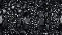 Dark water drops on black surface create dramatic macro photography pattern with varied bubble sizes and reflective highlights, abstract background texture.