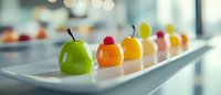 Colorful fruit desserts arranged in a row on white rectangular plate, showcasing elegant presentation for upscale restaurant or catering event.