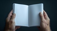 Male hands holding open blank book with empty white pages against dark background, ready for content placement.
