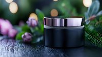 Black luxury cosmetic jar on wooden surface with pine branches, purple flowers and soft bokeh lights creating spa-like atmosphere. Suitable for beauty product marketing.