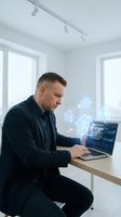 Professional Caucasian real estate agent analyzing property data on laptop with holographic house icons in modern office for digital marketing campaigns.