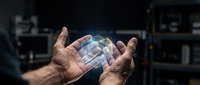 Hands holding a glowing holographic cube with futuristic digital light effects in a dark tech lab environment, symbolizing innovation and AI.