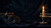 Ornate masquerade mask with glitter and feathers rests on dark fabric beside burning candle in brass holder, creating mysterious, elegant atmosphere for costume events and theatrical productions.