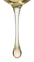 Isolated white wine dripping from glass bowl against white background, ready for design use on websites, menus, wine labels, and beverage marketing materials.