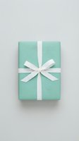 Elegant mint green gift box with white ribbon bow on light background, top view, for holiday, wedding, or birthday celebration concepts.