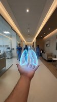 Holographic lungs projection floating above hand in modern hospital corridor with medical staff and equipment for healthcare technology concepts.