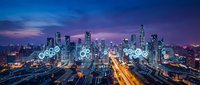 Illuminated gear icons float above a sprawling metropolitan skyline at dusk, symbolizing industrial innovation, smart city technology, and digital transformation in urban development and infrastructure.