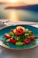 Fresh salad with prosciutto rose, cherry tomatoes, arugula and cucumber served on turquoise plate against sunset background, restaurant presentation.