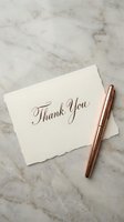 Elegant thank you card with copper pen on marble surface for wedding stationery and gratitude correspondence.