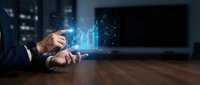 Businessman hand touching holographic financial data charts and graphs on smartphone in modern office for business analytics and market research.