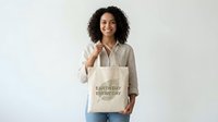 Young woman with dark curly hair and medium skin tone holding eco-friendly canvas tote bag with Earth Day message against white background for sustainable lifestyle marketing.