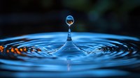 Macro photography of water drop impact creating concentric ripples on blue surface with orange reflections, frozen moment showing surface tension and droplet formation.
