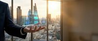 Business professional holding holographic growth chart in modern office with city skyline view during golden hour for corporate presentations.