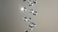 Sparkling crystal diamonds floating and falling through air with brilliant light reflections creating luxury jewelry concept for premium design projects.