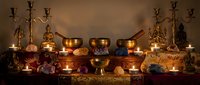 Mystical altar setup with copper bowls, brass candelabras, crystals and ritual items creating atmospheric spiritual workspace for meditation practices.