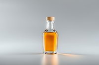 Small glass bottle with golden amber liquid and metal cap on light background with soft shadow and reflection, minimalist composition for beverage packaging.