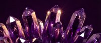 Purple amethyst crystal cluster with sparkling faceted gems on dark background for healing, meditation and spiritual wellness concepts.