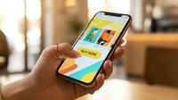 Woman's hand holding smartphone displaying colorful fashion shopping app with buy now button, mobile commerce and online retail concept.
