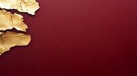Luxurious gold leaf fragments on deep burgundy background create elegant contrast and texture, suitable for luxury branding and high-end design projects.