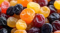 Colorful assorted dried fruits including apricots, prunes, dates and raisins arranged together. Healthy snack mix for nutrition and wellness concepts.
