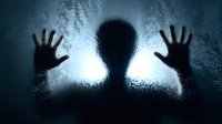 Dark silhouette of person with hands pressed against frosted glass creating mysterious atmospheric horror scene with dramatic backlighting and shadows.