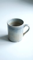 Handmade ceramic mug with blue gradient glaze on white background for kitchen and dining design projects.